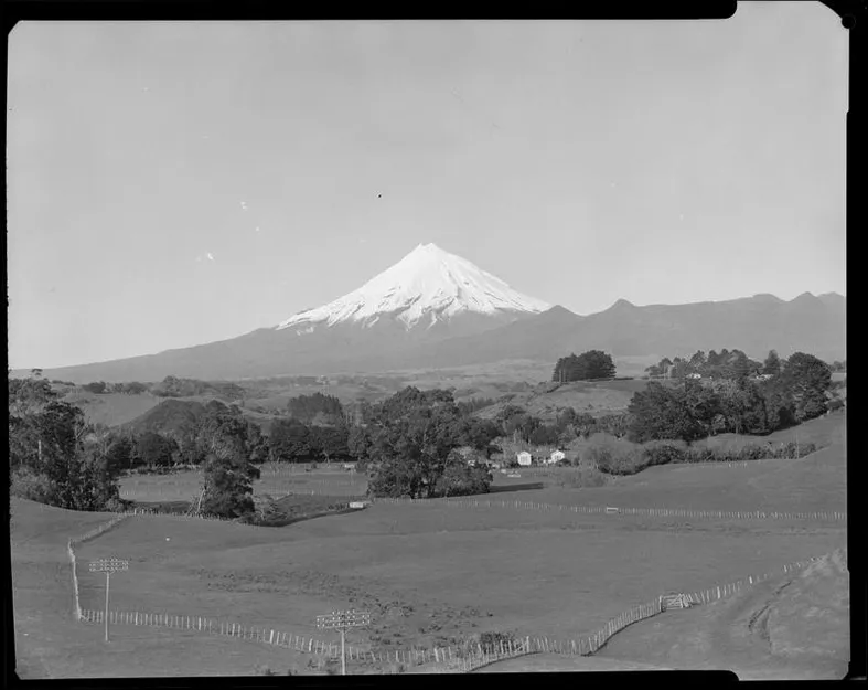 View of Mt. Taranaki with trees and homestead in foreground