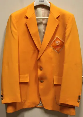 Orange double breasted Blazer with 1984 on badge at chest height.