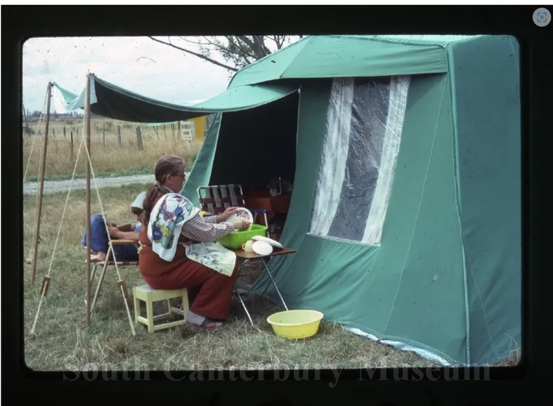 Woman outside tent doing dishes